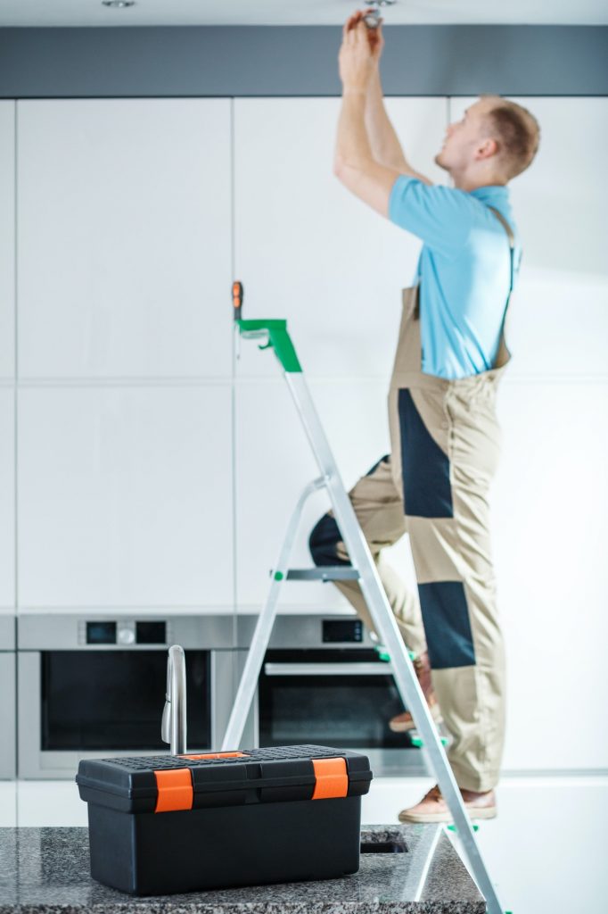 Professional electrician on ladder
